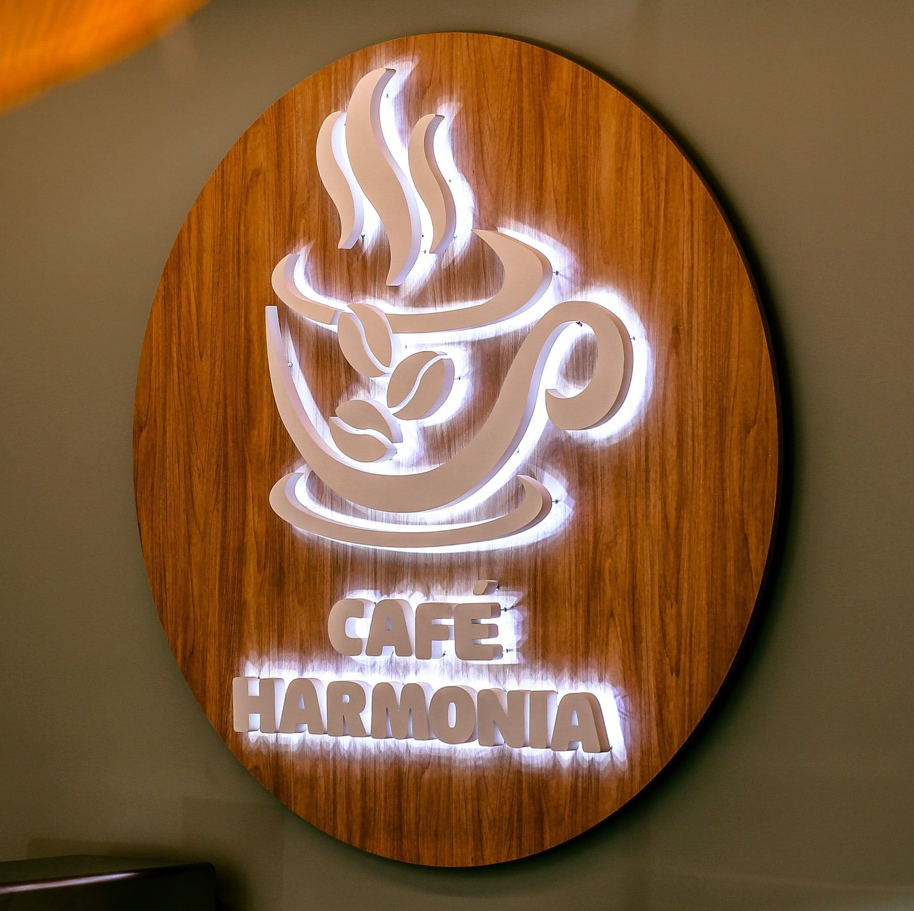 Letreiro iluminado do Café Harmonia na parede do salão